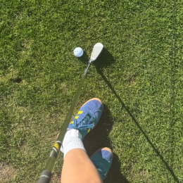 a person with a golf club and golf ball